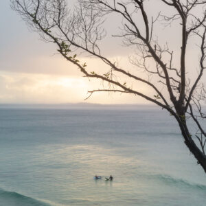 Two surfers in the water during sunset in Queensland's Noosa Heads